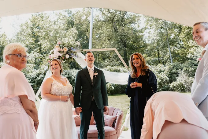 Wedding ceremony under tent with bride, groom, and guests
