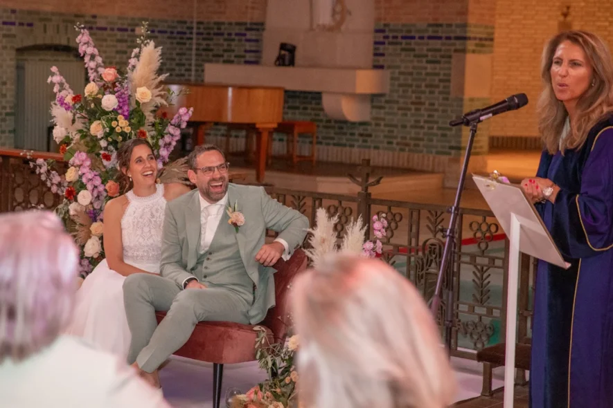Wedding ceremony with bride, groom, and officiant speaking at microphone