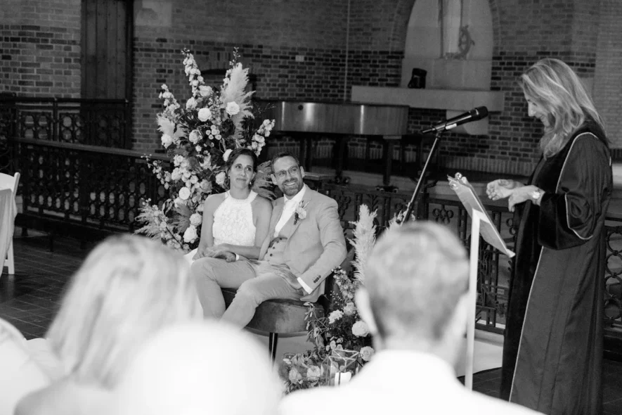 Wedding ceremony with bride, groom, and officiant speaking