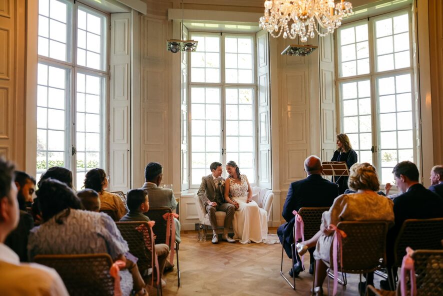 Elegant indoor wedding ceremony in grand hall with chandelier
