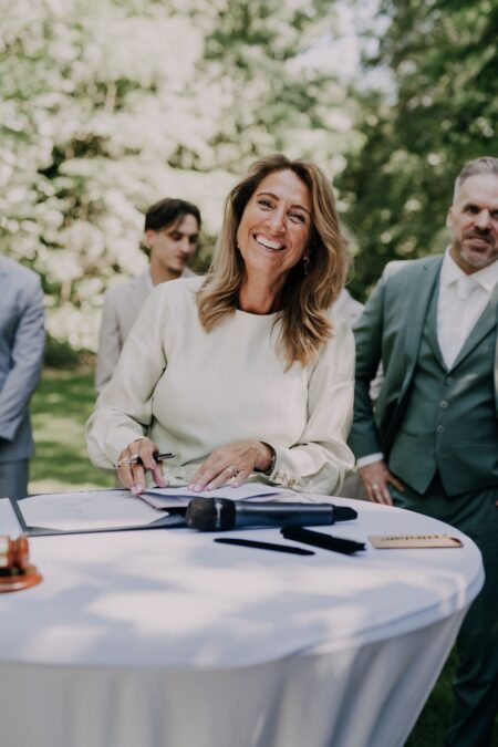 Woman signing documents at outdoor garden event table